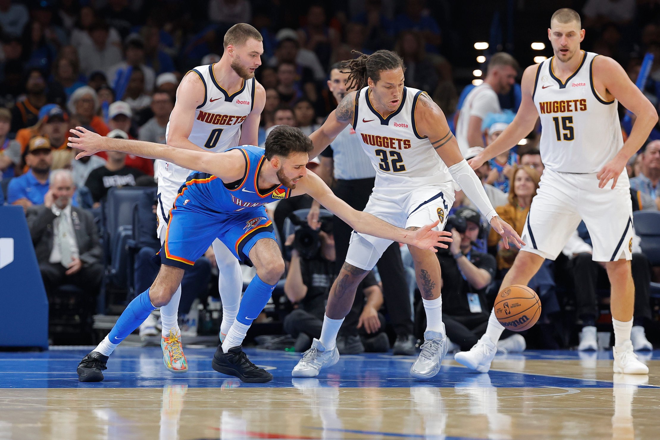 Oct 22, 2026; Oklahoma City, Oklahoma, USA; Oklahoma City Thunder center Chet Holmgren (7) and Denver Nuggets forward Aaron Gordon (32) reach for a loose ball during the second half at Paycom Center. Mandatory Credit: Alonzo Adams-Imagn Images