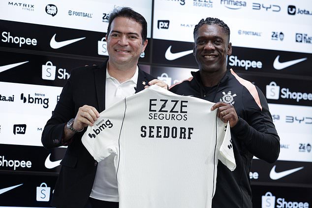 Clarence Seedorf, right, and Corinthians executive Marcelo Paz pose for a photo during a news conference presenting Seedorf as the new head coach of the Corinthians soccer team, in Sao Paulo, Wednesday, Oct. 14, 2026. (AP Photo/Ettore Chiereguini)