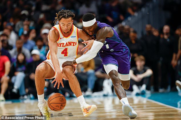 Atlanta Hawks guard Kingston Flemings (4) battles Charlotte Hornets guard Dennis Schroder, right, for the ball during the first half of an NBA basketball game in Charlotte, N.C., Friday, Oct. 23, 2026. (AP Photo/Nell Redmond)