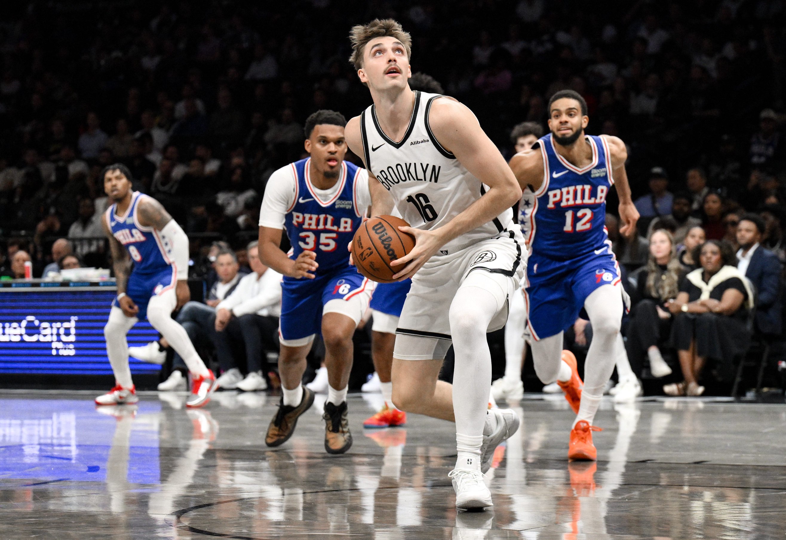 Oct 8, 2026; Brooklyn, New York, USA;  Brooklyn Nets forward Grant Nelson (16) drives past Dillon Jones (35) and Philadelphia 76ers guard Rayan Rupert (12) during the second half at Barclays Center.  Mandatory Credit: John Jones-Imagn Images