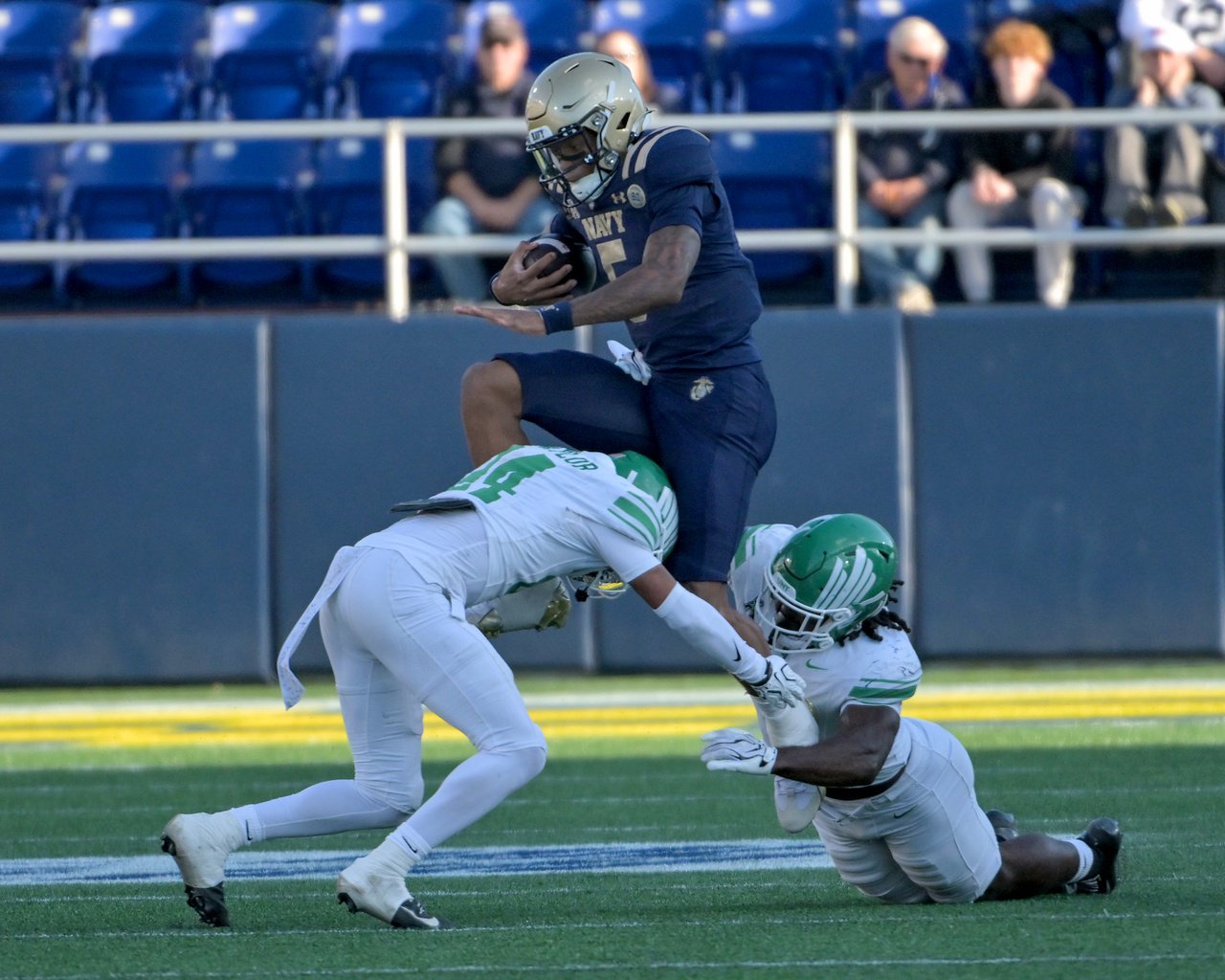 Navy Midshipmen Braxton Woodson #5 leaps between North Texas Mean Green defensive back CJ Coombes #4, left and linebacker Aaron Alexander #7 in the second quarter. The Navy Midshipmen host the visiting North Texas Mean Green in an NCAA football game Saturday at Navy-Marine Corps Memorial Stadium in Annapolis. (Paul W. Gillespie/Staff)