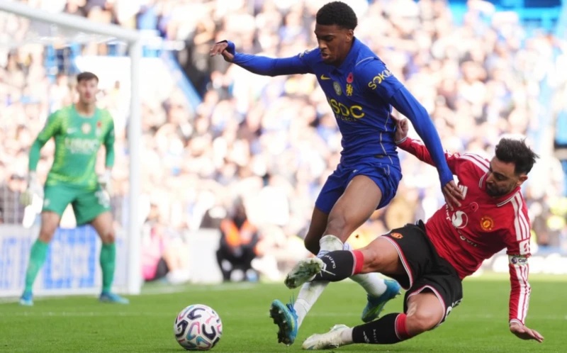 Chelsea's Josh Acheampong and Manchester United's Bruno Fernandes (right) battle for the ball d