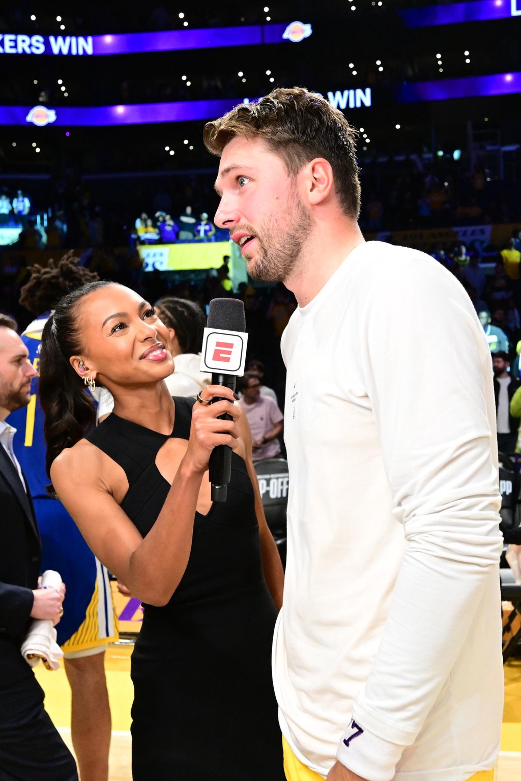 An ESPN reporter interviewing a basketball player on the court.