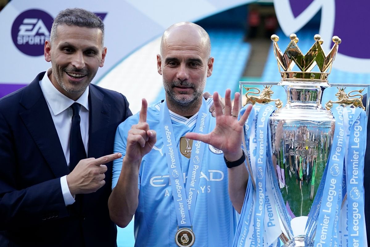 Manchester City's head coach Pep Guardiola, right, and chairman Khaldoon Al Mubarak celebrate with the Premier League trophy after the English Premier League soccer match between Manchester City and West Ham United in Manchester, England, Sunday, May 19, 2024