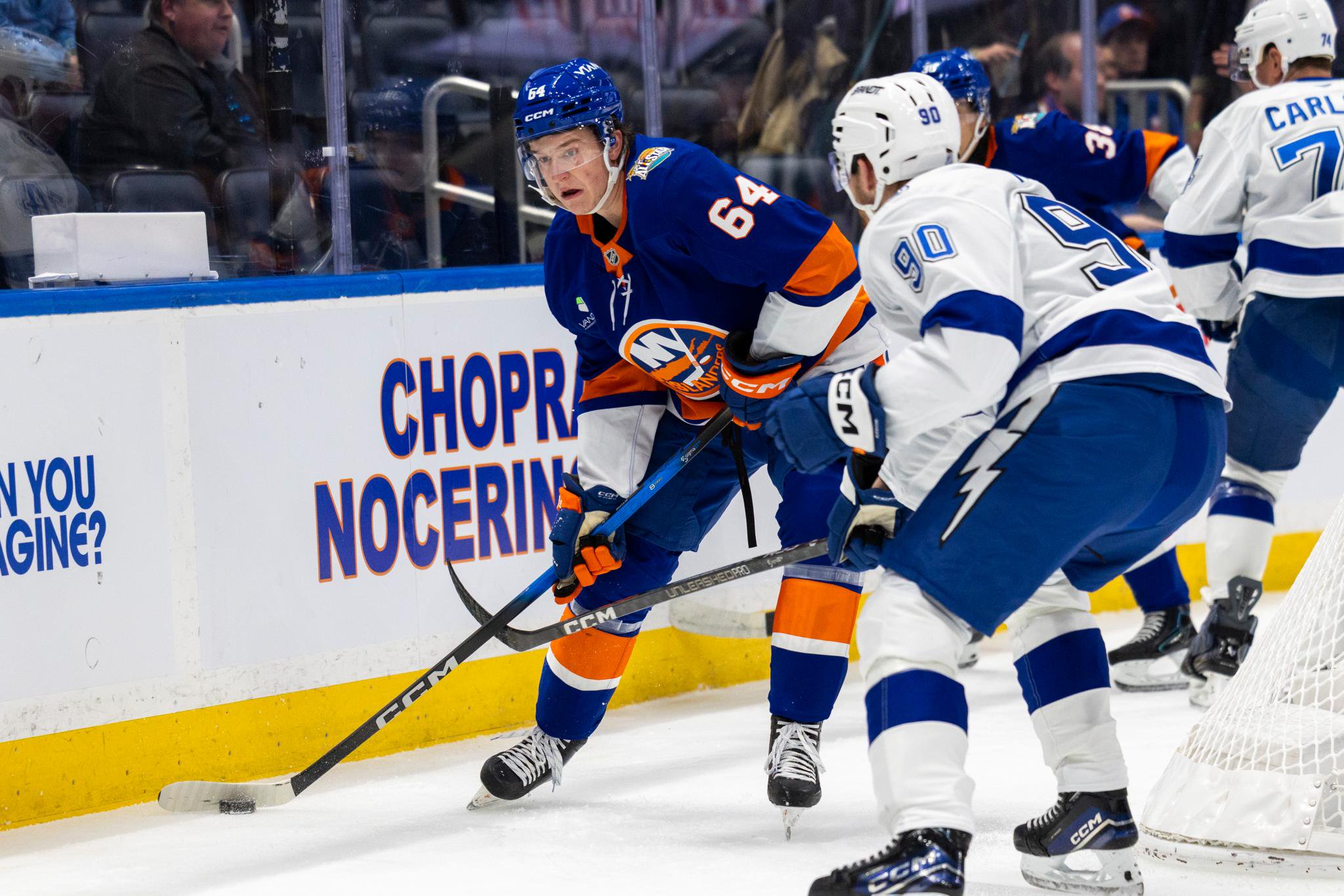 New York Islanders center Calum Ritchie (64) moves the puck as Tampa Bay Lightning defenseman J.J. Moser (90) defends.