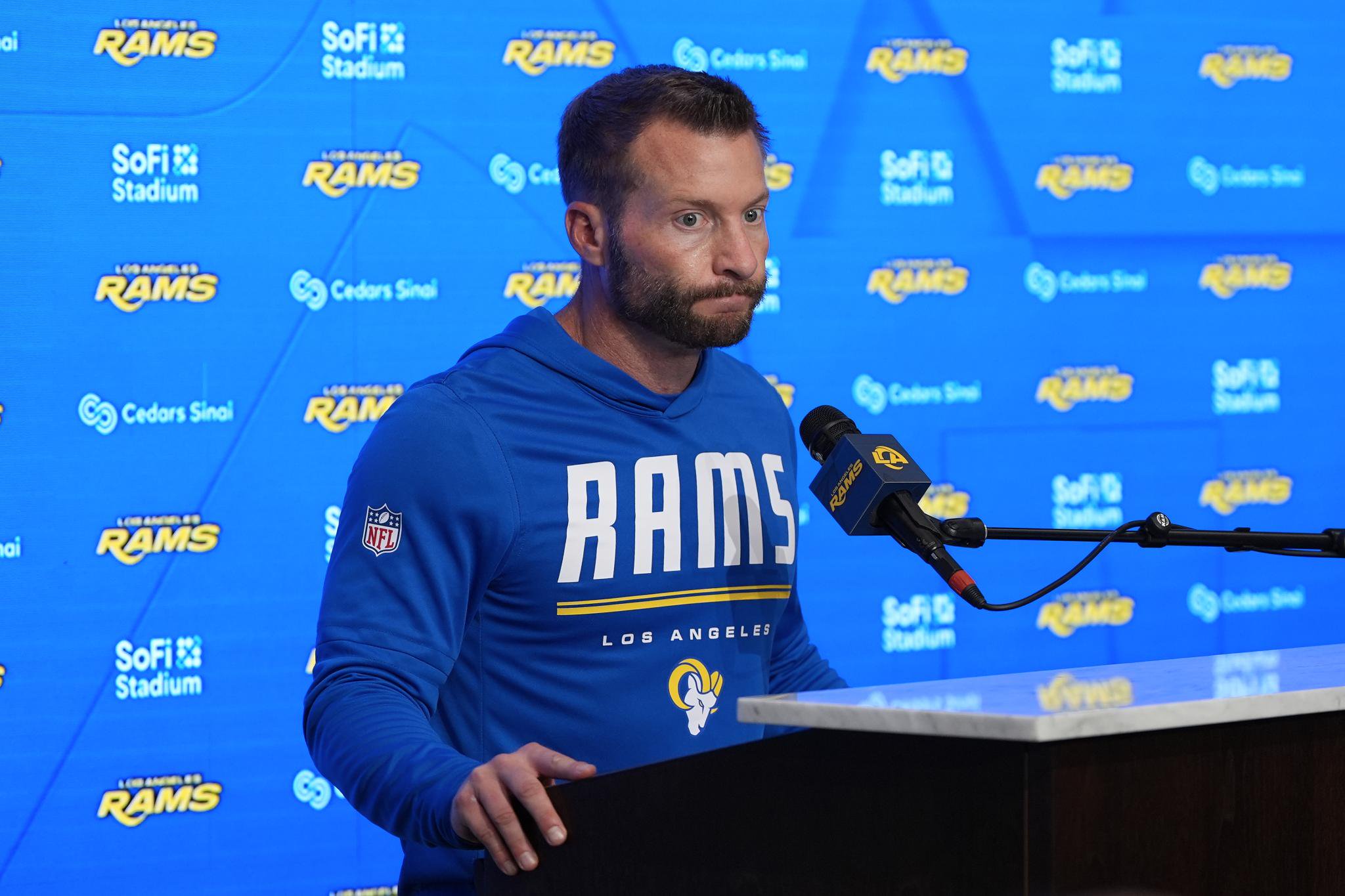Sean McVay at a podium in front of a blue Los Angeles Rams backdrop.