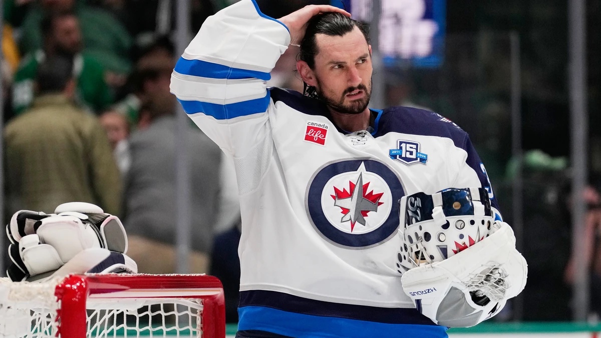 FILE - Winnipeg Jets goaltender Connor Hellebuyck stands by the net during a time out from play against the Dallas Stars in the first period of an NHL hockey game, April 2, 2026, in Dallas. (AP Photo/ ...