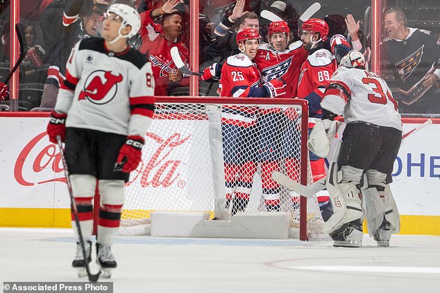 Washington Capitals' Jordan Kyrou (25), Dylan Strome (17) and Alex Tuch (89) celebrate after Strome scored a goal during the second period of an NHL hockey game against New Jersey Devils, Saturday, Oct. 17, 2026, in Washington. (AP Photo/Nathan Howard)