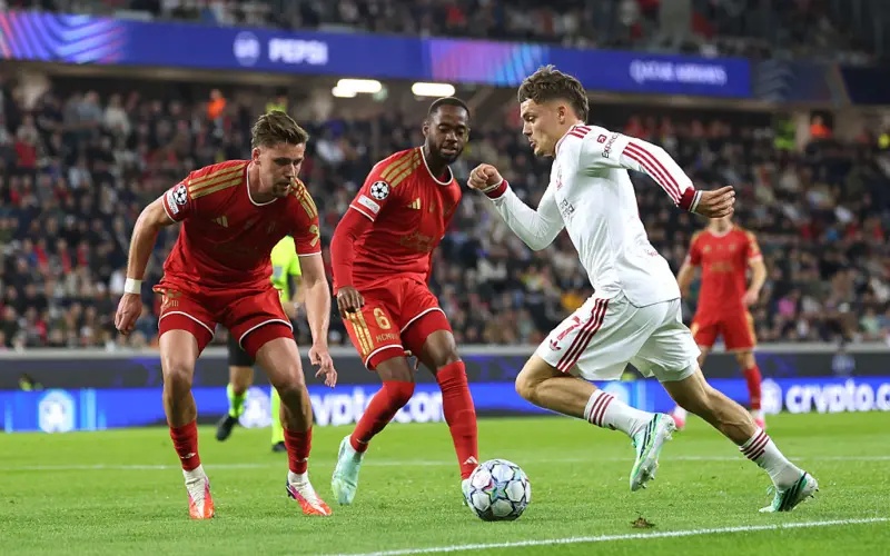 Florian Wirtz of Liverpool runs with the ball under pressure from Melayro Bogarde and Kasper Jorgensen of LASK