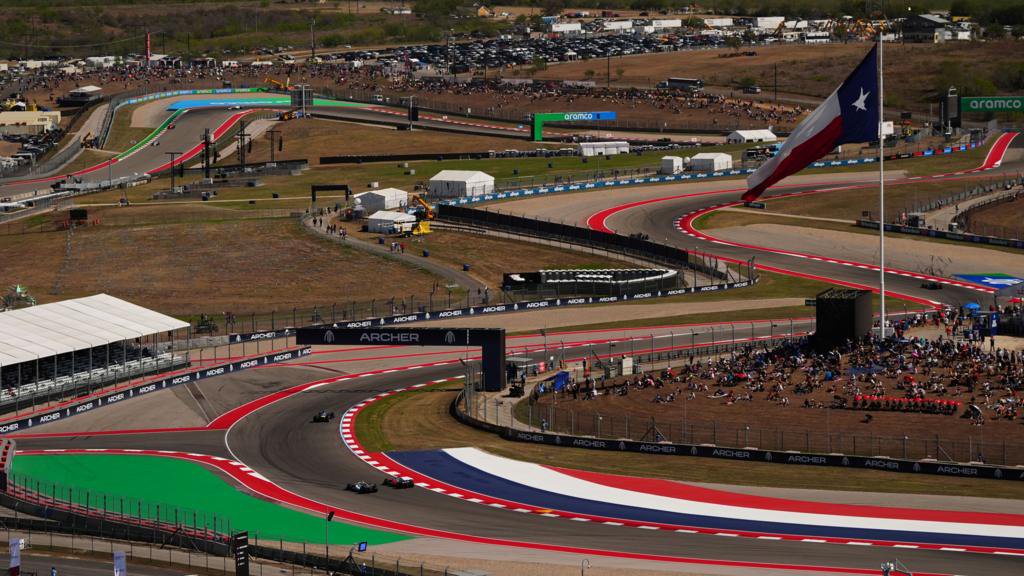 An aerial image looking down at the sweeping bends of the Circuit of the Americas with Formula 1 cars on track