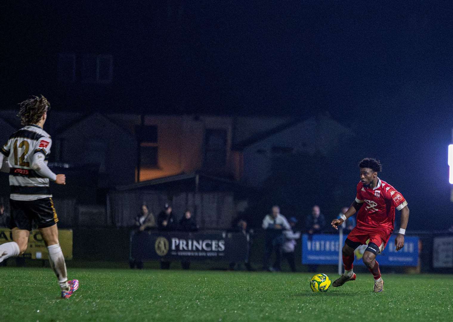 Henry Sinai, of Faversham Town, prepares to take on Deal substitute Dillon Simmons. Picture: Nathan Munday