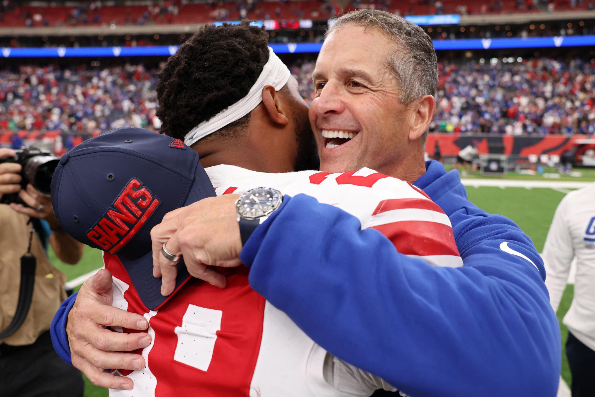 New York Giants head coach John Harbaugh and Tyrone Tracy Jr. embrace after a game.