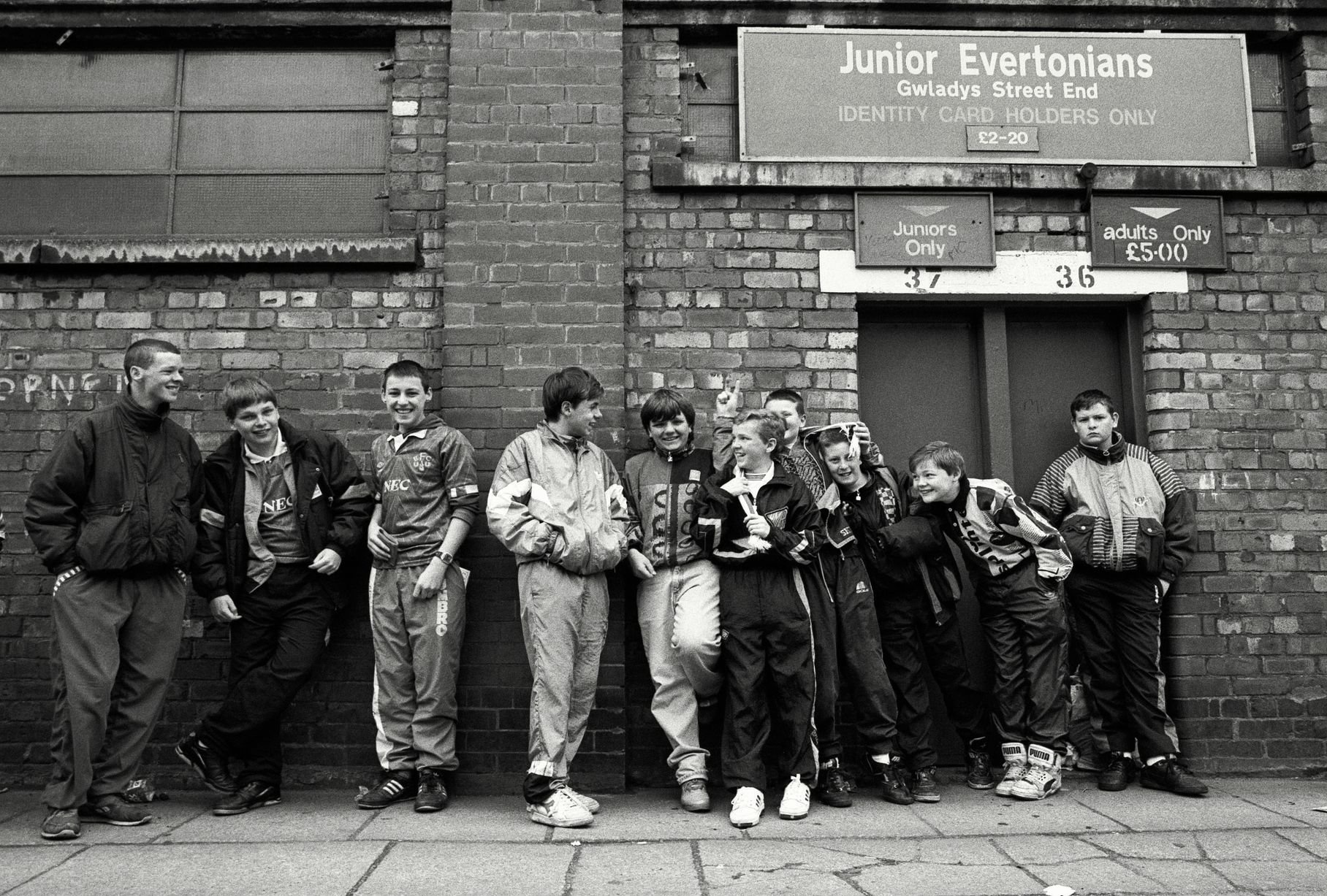 In 1991, photographer Richard Davis followed supporters from across the North West for a book about football, fashion and music. Richard spent much of the season taking pictures of fans from Liverpool, Everton and more for the book Football With Attitude. In collaboration with Lower Block, the Going to the Match zine has been published to coincide with an exhibition of the same name at Bury Art Museum, running from October 2024 to March 2025.
Pictured: Everton fans at Goodison Park, 1991