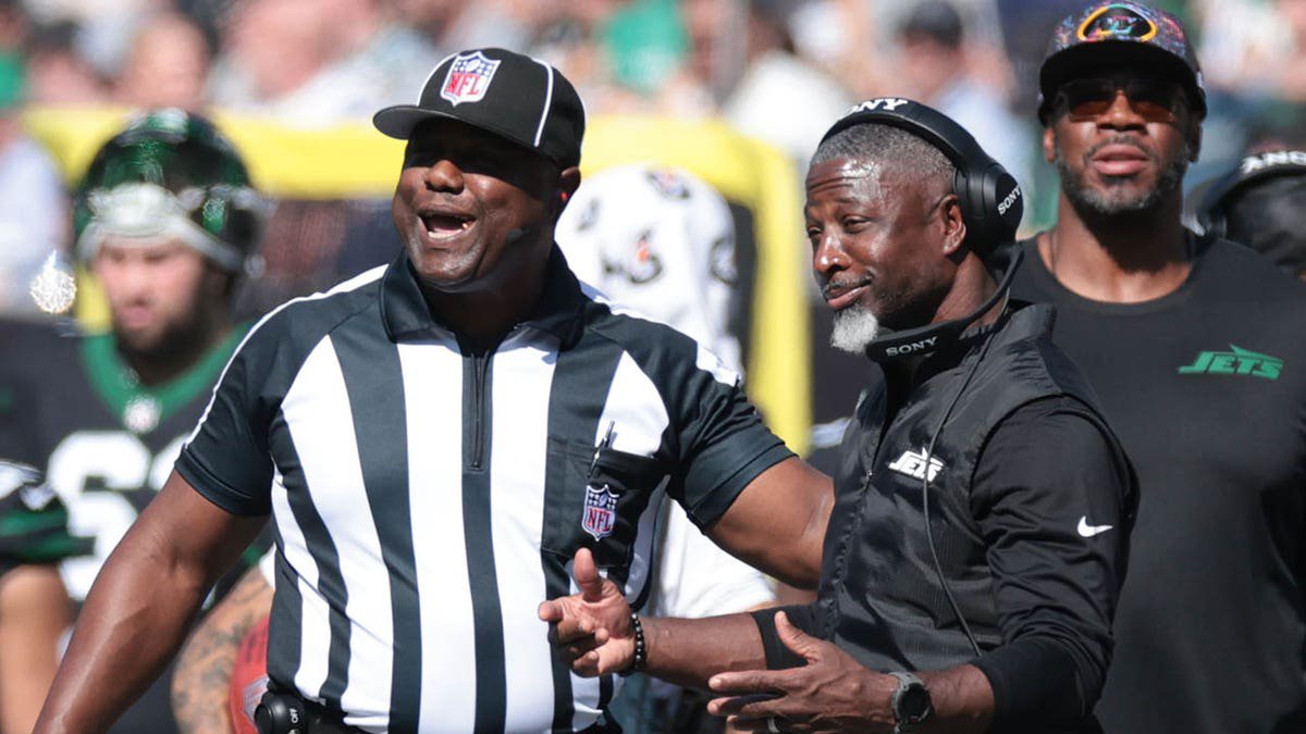 Aaron Glenn talks to the ref