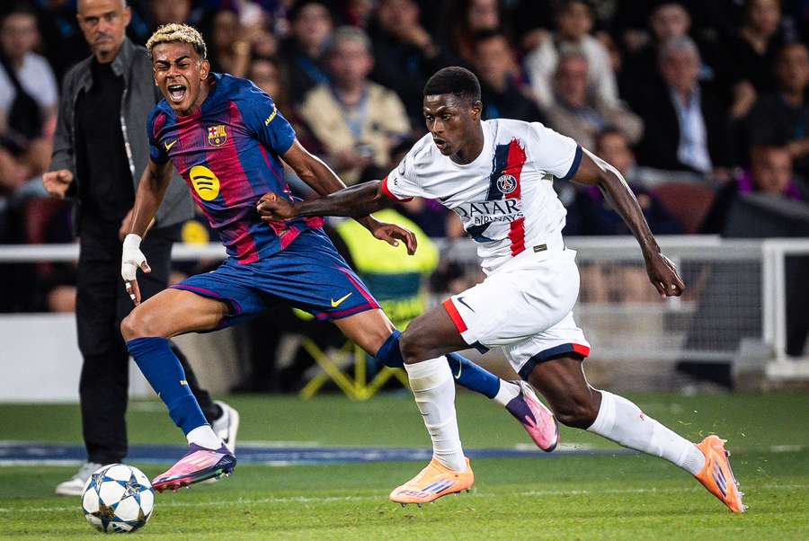 Barcelona's Lamine Yamal is challenged by PSG's Nuno Mendes