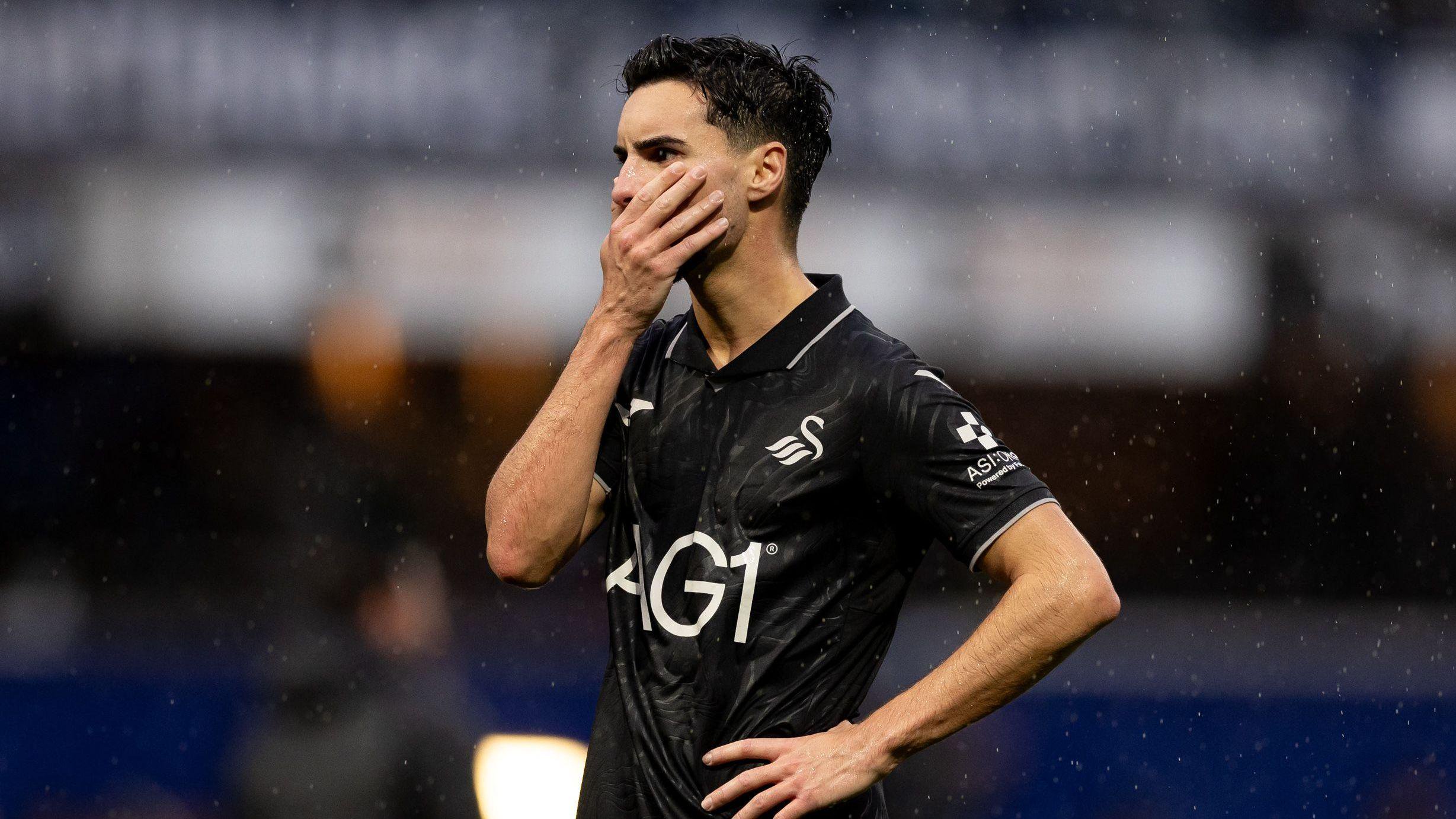 Stephen Eustaquio in all black looks dejected after Swansea's defeat at QPR 