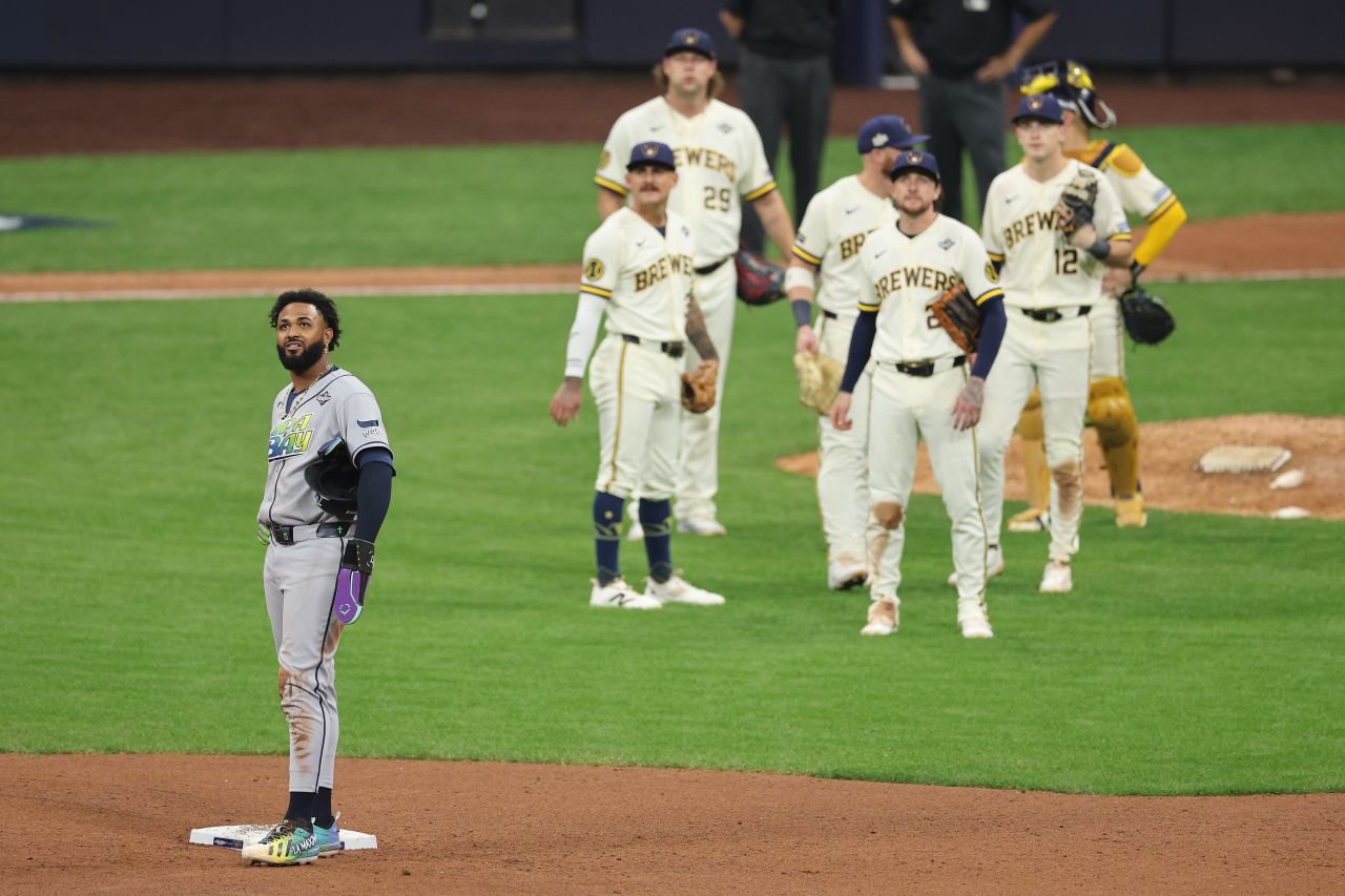 Tampa Bay's Junior Caminero, left, and some Brewers players watch the video screen during a review in the ninth inning.
