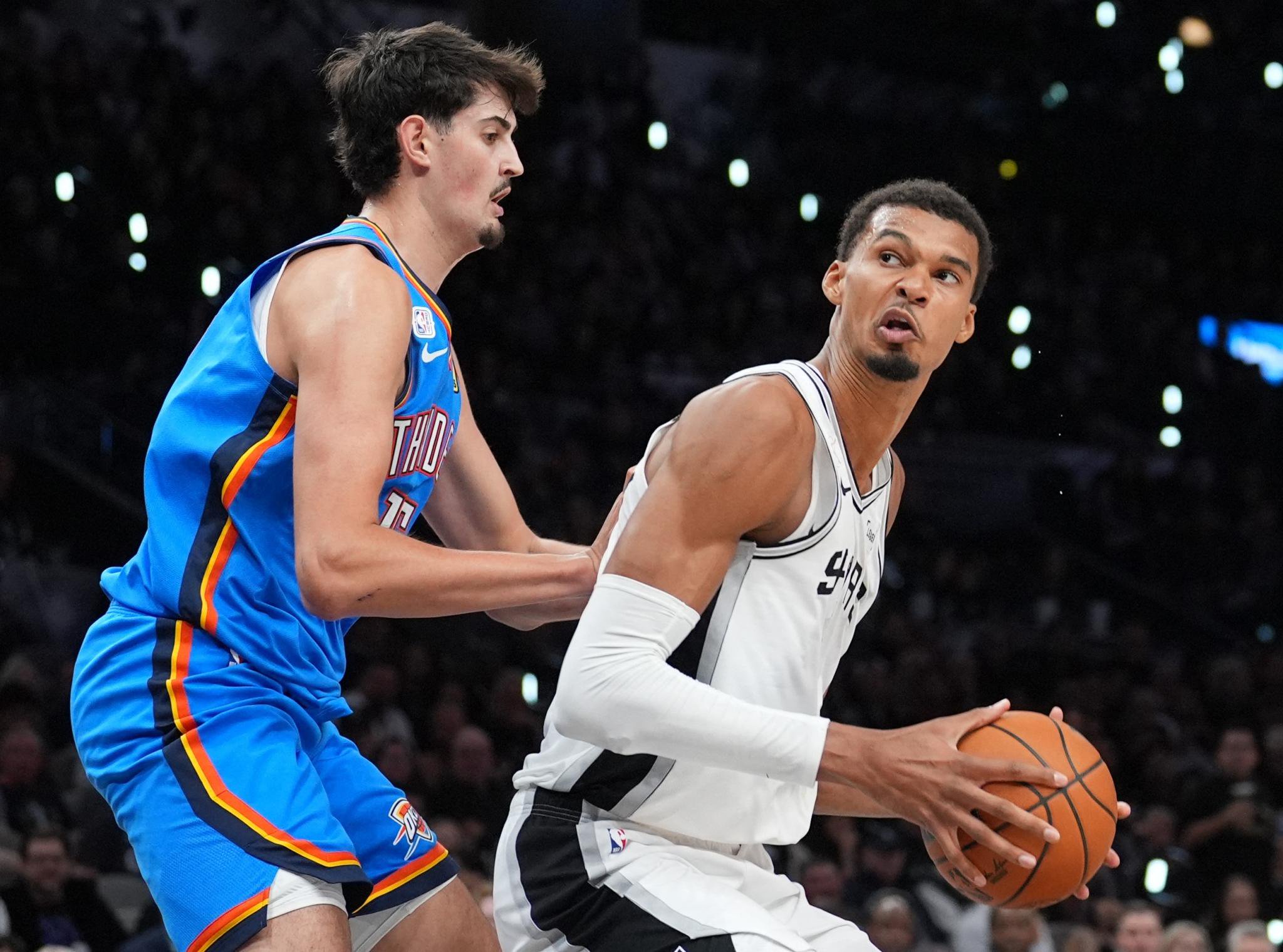 Victor Wembanyam, who scored just 12 points, looks to make a move on Aday Mara during the Spurs' loss to the Thunder.