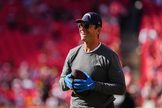 Los Angeles Chargers head coach Jim Harbaugh handles the ball as he watches warmups before an NFL football game against the Kansas City Chiefs in Kansas City, Mo., Sunday, Oct. 18, 2026. (AP Photo/Ed Zurga)