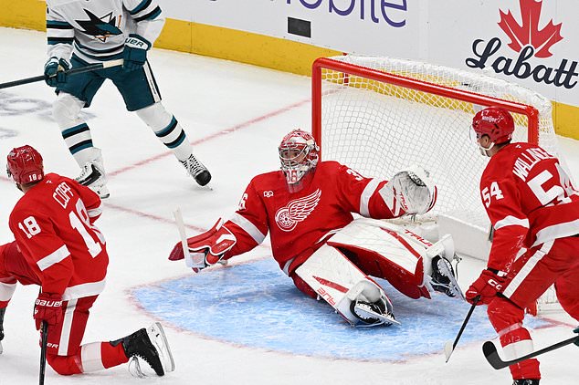 Detroit Red Wings goaltender John Gibson, center, kicks his legs out and makes a save during the first period of an NHL hockey game against the Detroit Red Wings, Saturday, Oct. 17, 2026, in Detroit. (AP Photo/Jose Juarez)