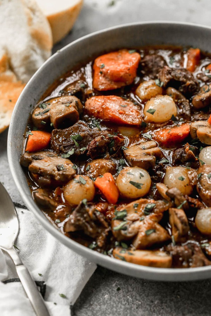 A bowl of beef Bourguignon with carrots and mushrooms