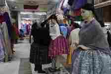 Celia Jaliri places a hat on a mannequin while waiting for customers in her clothing store for Cholitas in La Paz, Bolivia, Saturday, June 29, 2024, days after Army troops stormed the government palace in what President Luis Arce called a coup attempt. (AP Photo/Juan Karita)