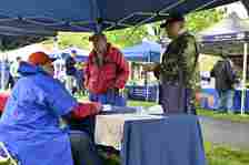 Tony Roman, Case Manager at Carroll County Government Veterans Department, seated, speaks to veterans to try to connect them to services during the 3rd annual Veterans Celebration of Carroll County at the Farm Museum in Westminster.(Thomas Walker/Freelance)