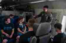 Senior Airman Christian Conde, 960th Airborne Air Control Squadron mission systems operator explains his duties to Premiere College Intern Program members, June 26, at Tinker Air Force Base, Oklahoma.