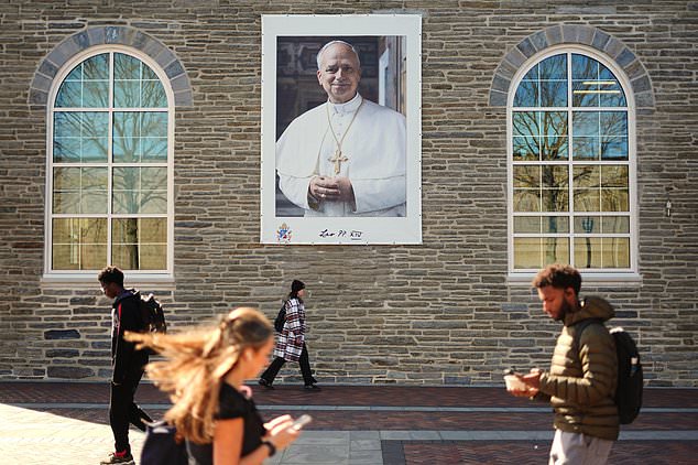 Students walk past an image of Pope Leo XIV at Villanova University in Villanova, Pa., Wednesday, Oct. 21, 2026. (AP Photo/Matt Rourke)