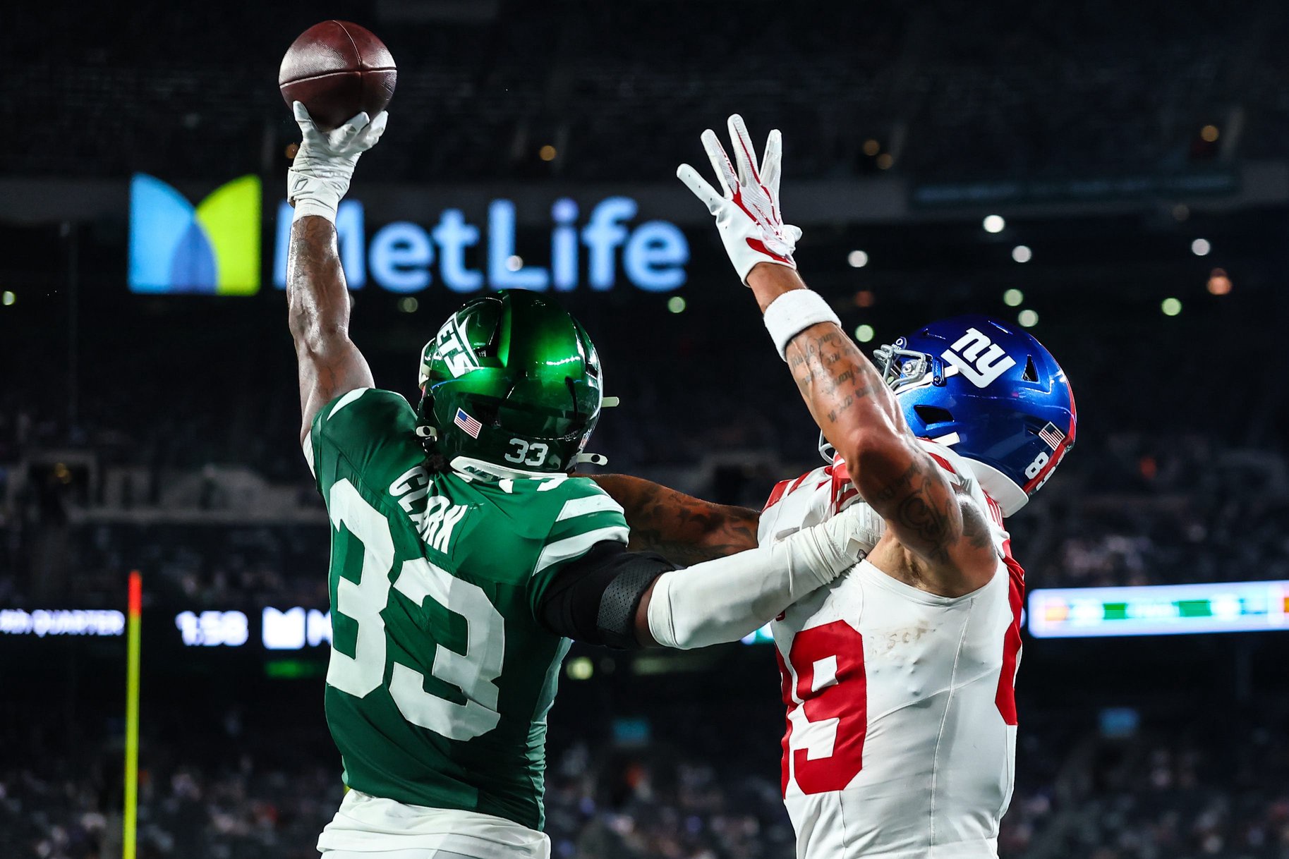 Aug 28, 2026; East Rutherford, New Jersey, USA; New York Jets cornerback Jordan Clark (33) breaks up a pass intended for New York Giants wide receiver Isaiah Hodgins (89) during the second half at MetLife Stadium. Clark was called for defensive holding on the play. Mandatory Credit: Vincent Carchietta-Imagn Images