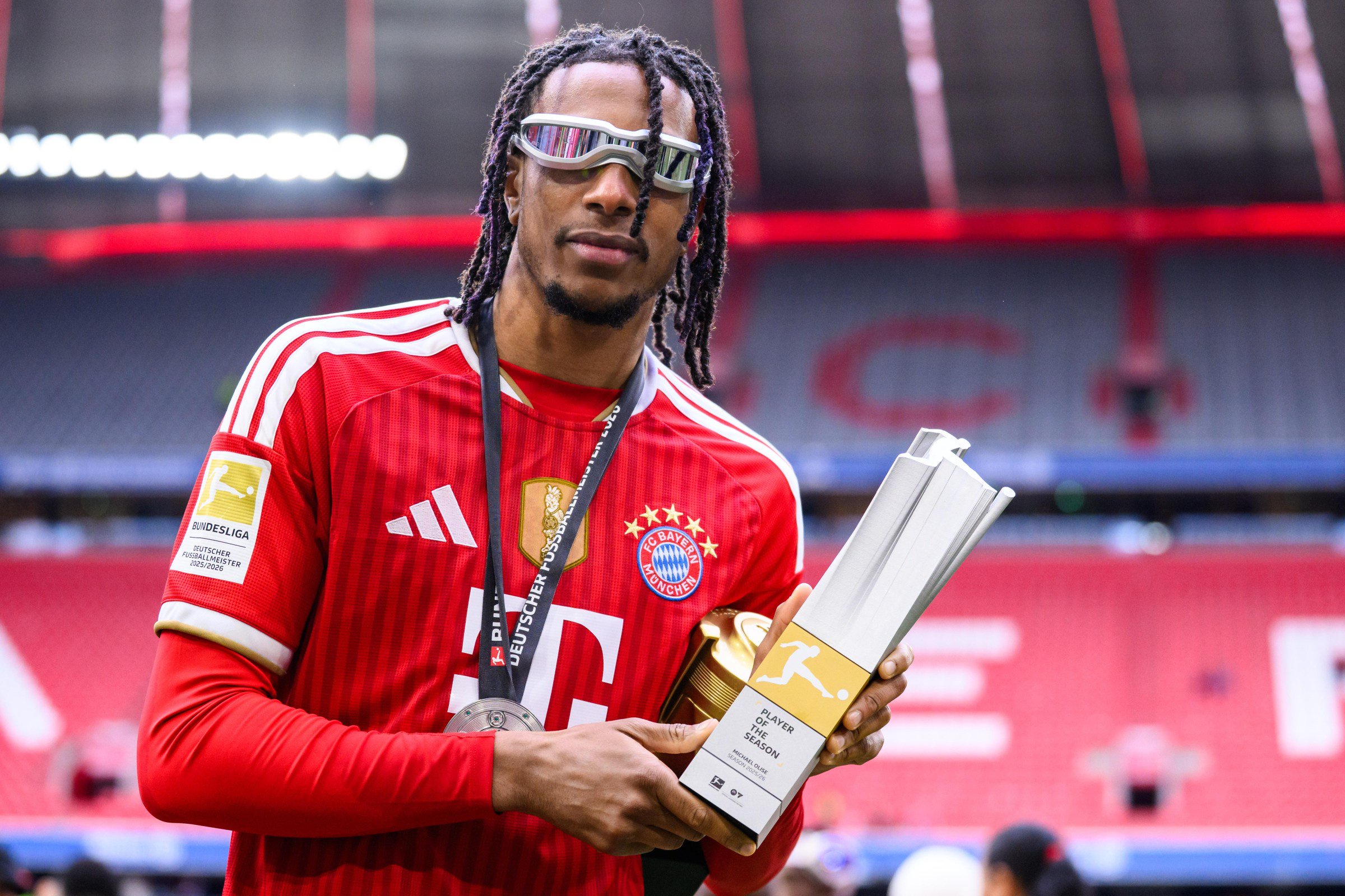 16 May 2026, Bavaria, Munich: Soccer, Men: Bundesliga, Bayern Munich - 1. FC Köln, Matchday 34, Allianz Arena. Michael Olise (Bayern Munich) with the trophy for “Player of the Season”. Photo: Tom Weller/dpa - IMPORTANT NOTE: In accordance with the regulations of the DFL German Football League and the DFB German Football Association, it is prohibited to utilize or have utilized photographs taken in the stadium and/or of the match in the form of sequential images and/or video-like photo series. (Photo by Tom Weller/picture alliance via Getty Images)