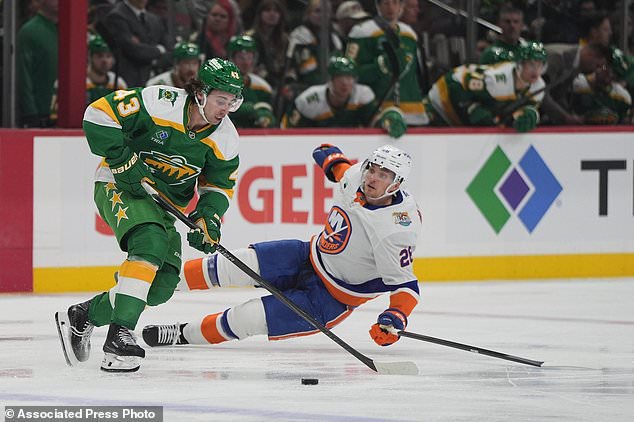 Minnesota Wild defenseman Quinn Hughes (43) controls the puck as New York Islanders right wing Mitchell Chaffee, back, defends during the second period of an NHL hockey game, Thursday, Oct. 29, 2026, in St. Paul, Minn. (AP Photo/Abbie Parr)