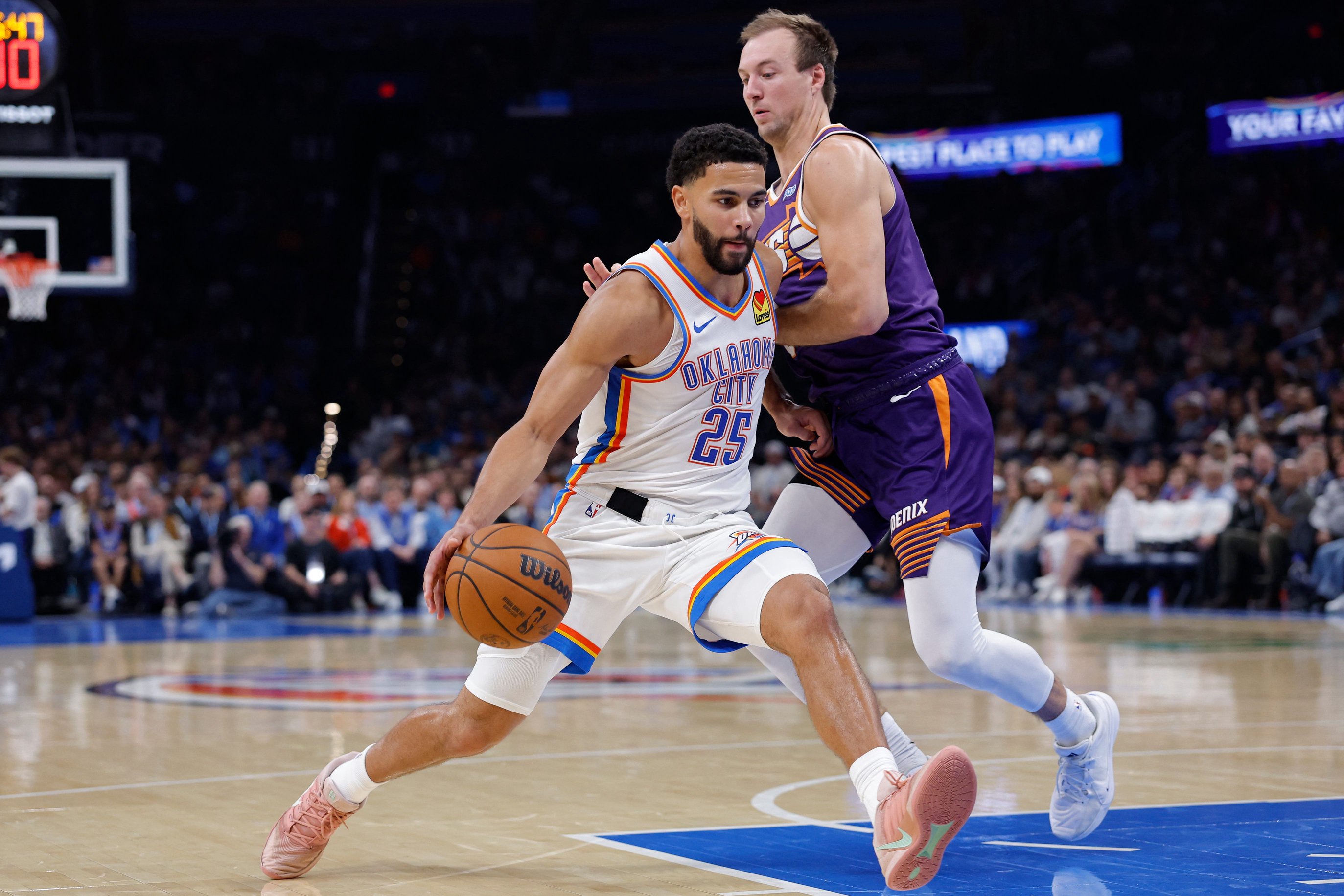 Oct 26, 2026; Oklahoma City, Oklahoma, USA; Oklahoma City Thunder guard Ajay Mitchell (25) drives past Phoenix Suns guard Luke Kennard (8) during the second half at Paycom Center. Mandatory Credit: Alonzo Adams-Imagn Images