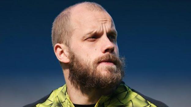 Teemu Pukki in a yellow and black Norwich City training kit.