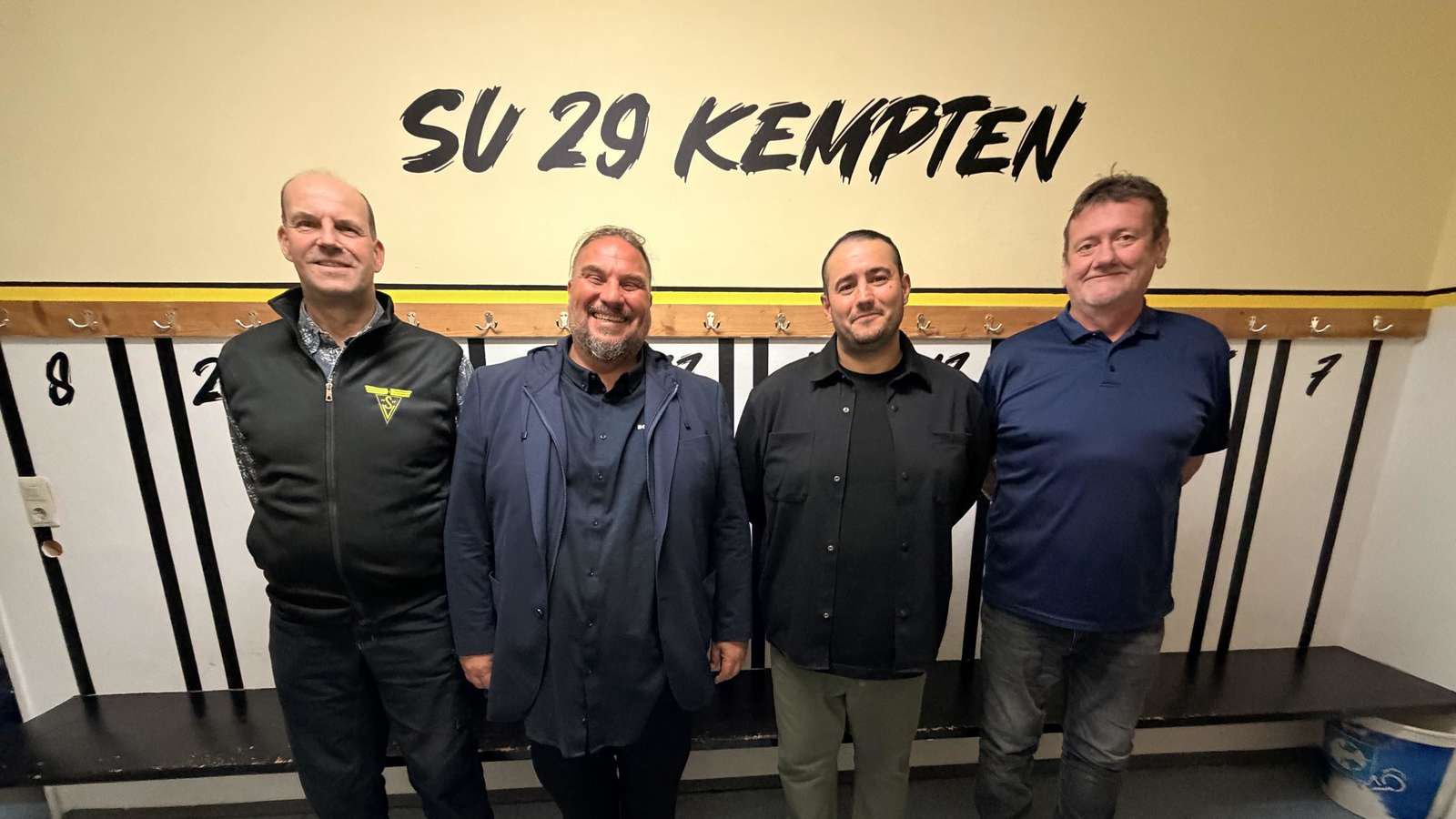 Menschen haben sich zum Foto aufgestellt und lächeln in die Kamera.