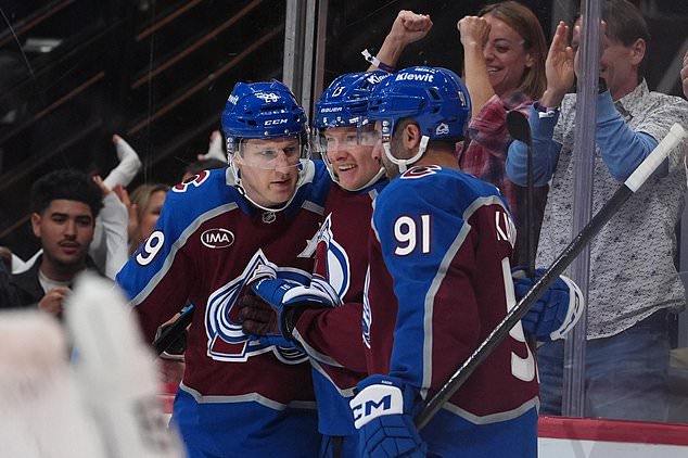 Colorado Avalanche center Nathan MacKinnon, left, and right wing T.J. Hughes, center, congratulate center Nazem Kadri (91) after his goal against the Tampa Bay Lightning in the first period of an NHL hockey game Friday, Oct. 23, 2026, in Denver. (AP Photo/David Zalubowski)