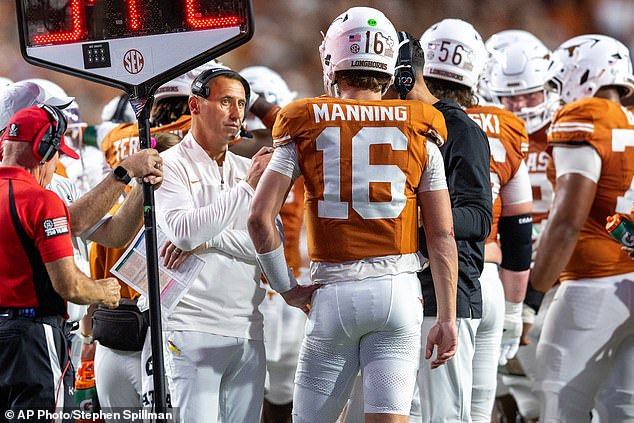 Texas head coach Steve Sarkisian, center left, speaks to Manning on the sideline in Austin