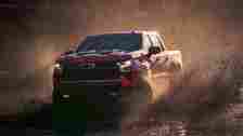 2024 Chevrolet Silverado 1500 In red driving through deep muddy river