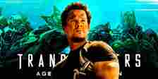 Mark Wahlberg holds a gun in front of Transformers: Age of Extinction artwork