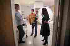 Three people and a toddler stand inside an MRI room. Researchers at OHSU's Center for Mental Health Innovation have identified novel biomarkers related to body fat composition during pregnancy are associated with mental health outcomes in offspring. (OHSU/Christine Torres Hicks)