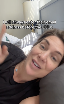 Woman in bed gestures while text on screen reads about entering an email address before CEOs&#x27;