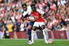 Tottenham defender Destiny Udogie challenges Arsenal's Bukayo Saka for the ball