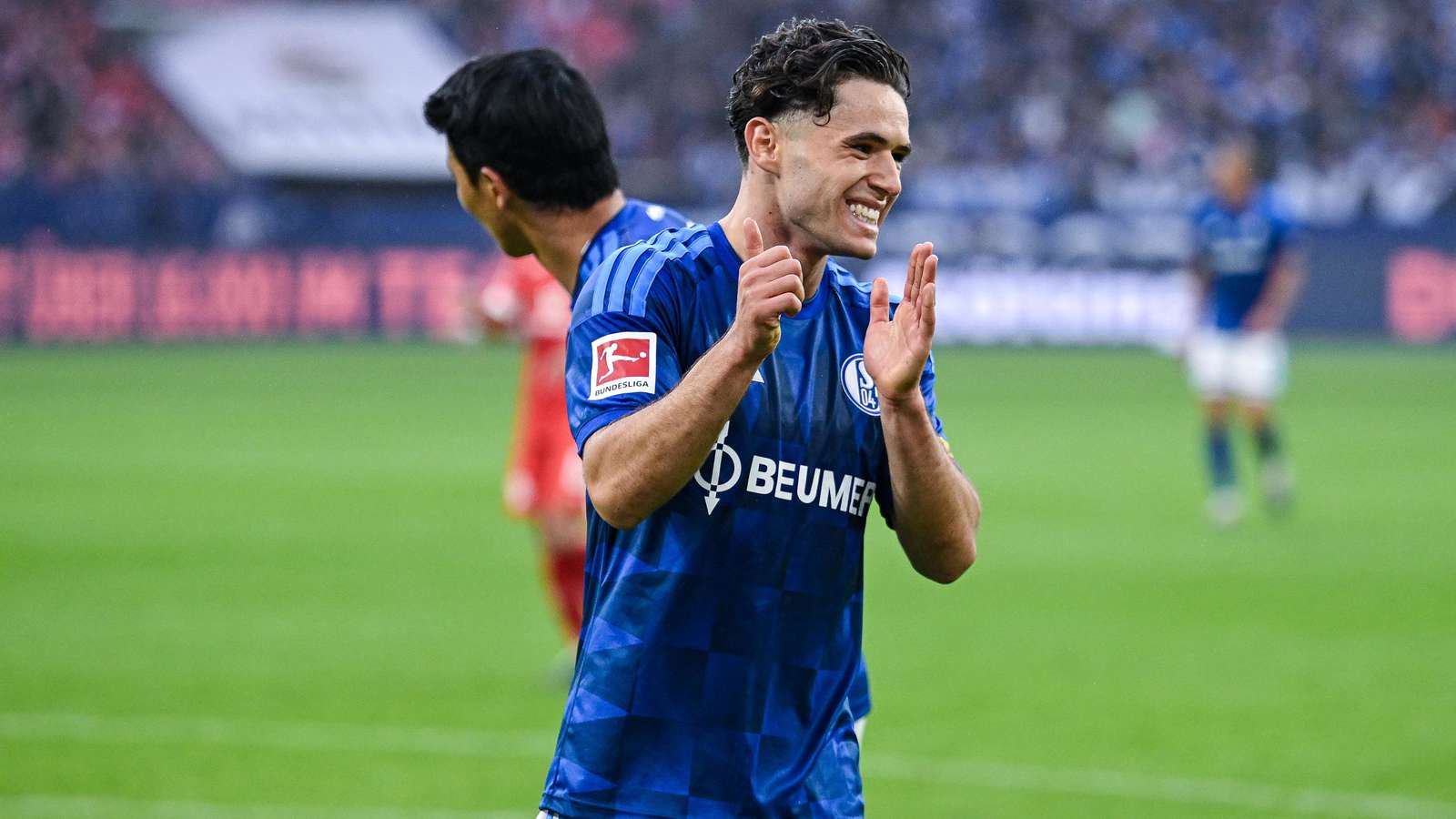 Soufiane El-Faouzi lächelt im Schalke-Heimtrikot 2026/27.