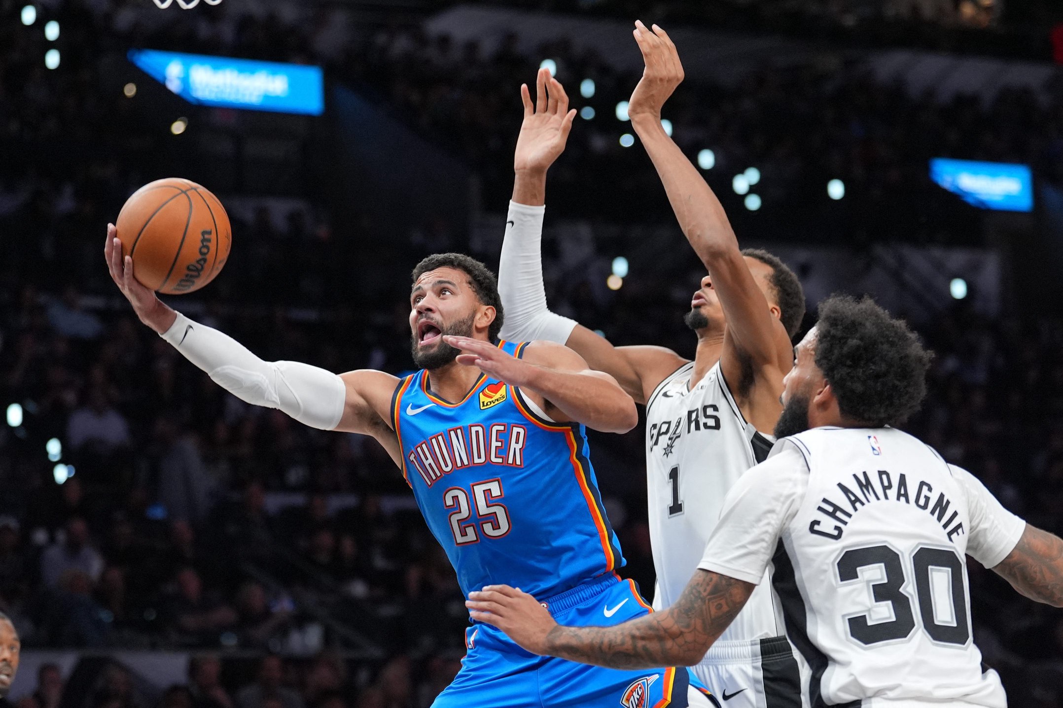 Oct 20, 2026; San Antonio, Texas, USA;  Oklahoma City Thunder guard Ajay Mitchell (25) shoots in front of San Antonio Spurs forwards Victor Wembanyama (1) and Julian Champagnie (30) in the first half at Frost Bank Center.  Mandatory Credit: Daniel Dunn-Imagn Images