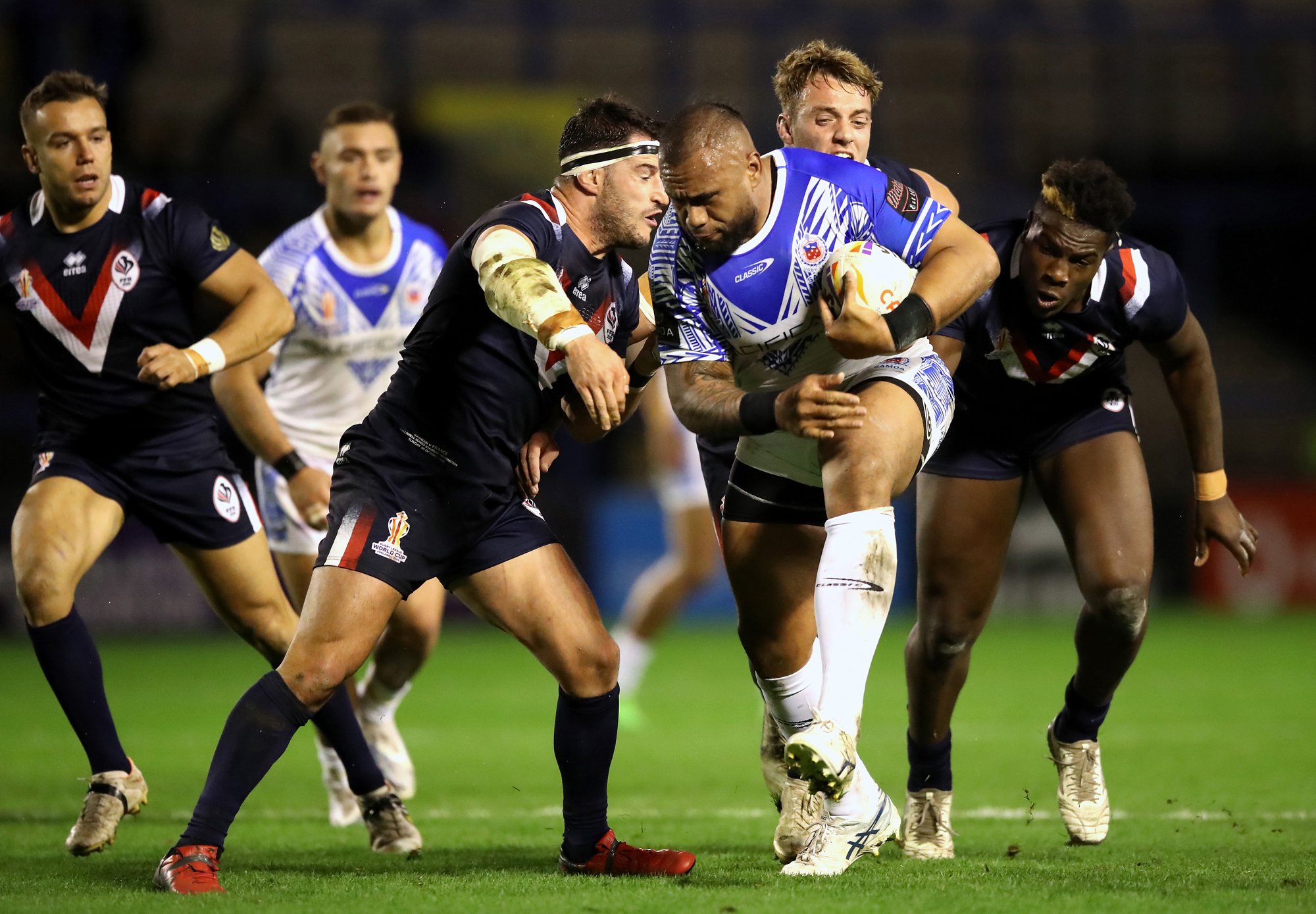 Samoa's Junior Paulo tries to break past France's Benjamin Garcia during the 2021 Rugby League World Cup match at the Halliwell Jones Stadium in Warrington