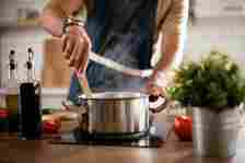 man sitting something in a steaming pot on a stovetop
