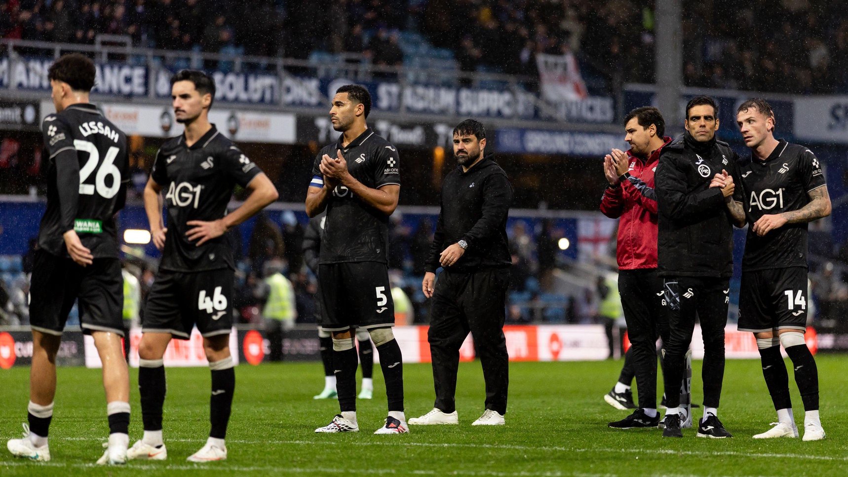 Swansea players and staff look dejected after defeat at QPR 