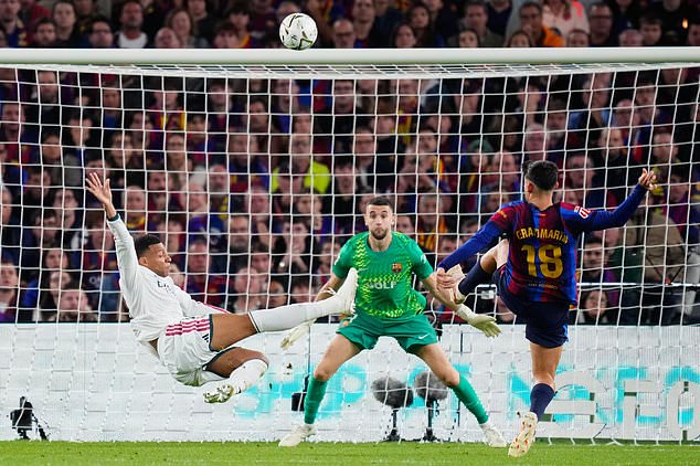 Real Madrid's Kylian Mbappe, left, attempts a shot at goal and misses in front of Barcelona's Gerard Martin, right, and Barcelona's goalkeeper Joan Garcia during a Spanish La Liga soccer match between FC Barcelona and Real Madrid in Barcelona, Spain, Sunday, Oct. 25, 2026. (AP Photo/Jose Breton)