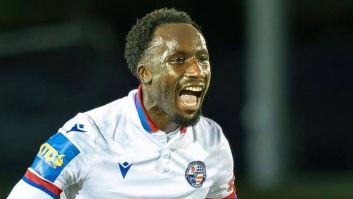 Joel Nketia in a white AFC Rushden and Diamonds jersey, celebrates during a match.