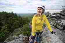 woman in yellow jacket on the eagle cliff via ferrata at mohonk mountain house